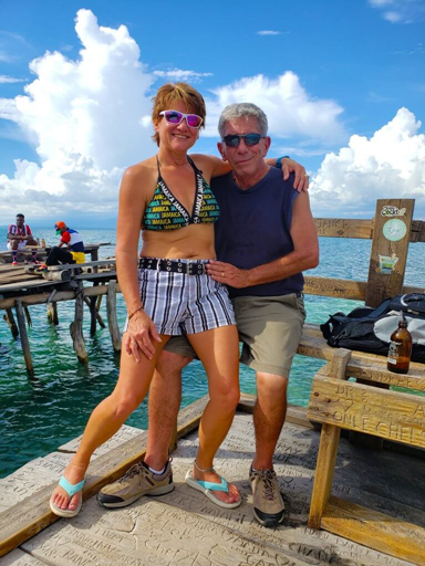 A woman sitting on her husbands lap on a dock at Floyd's Pelican Bar in Jamaica