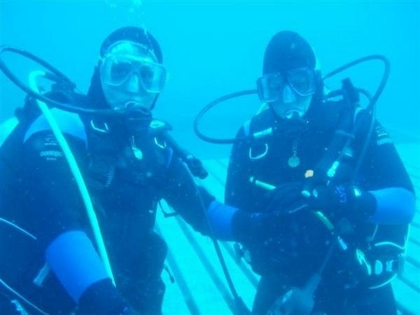 man and woman in full scuba gear